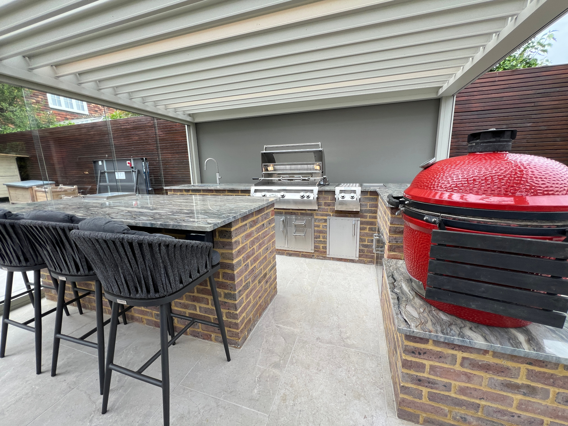 Outdoor kitchen with grill, Kamado and living wall under pergola