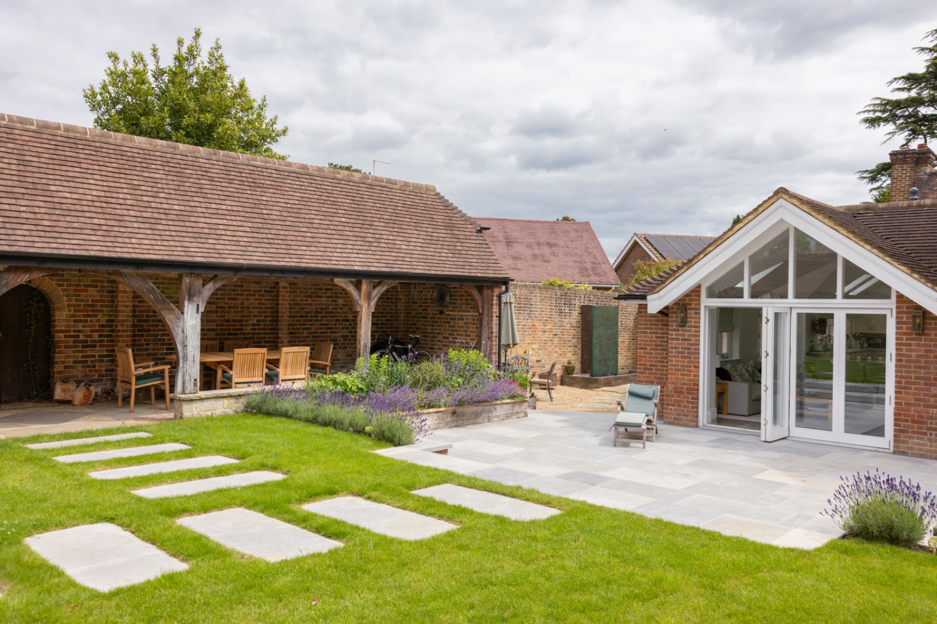 Sandstone patio with stepping-stone lawn leading to garden room