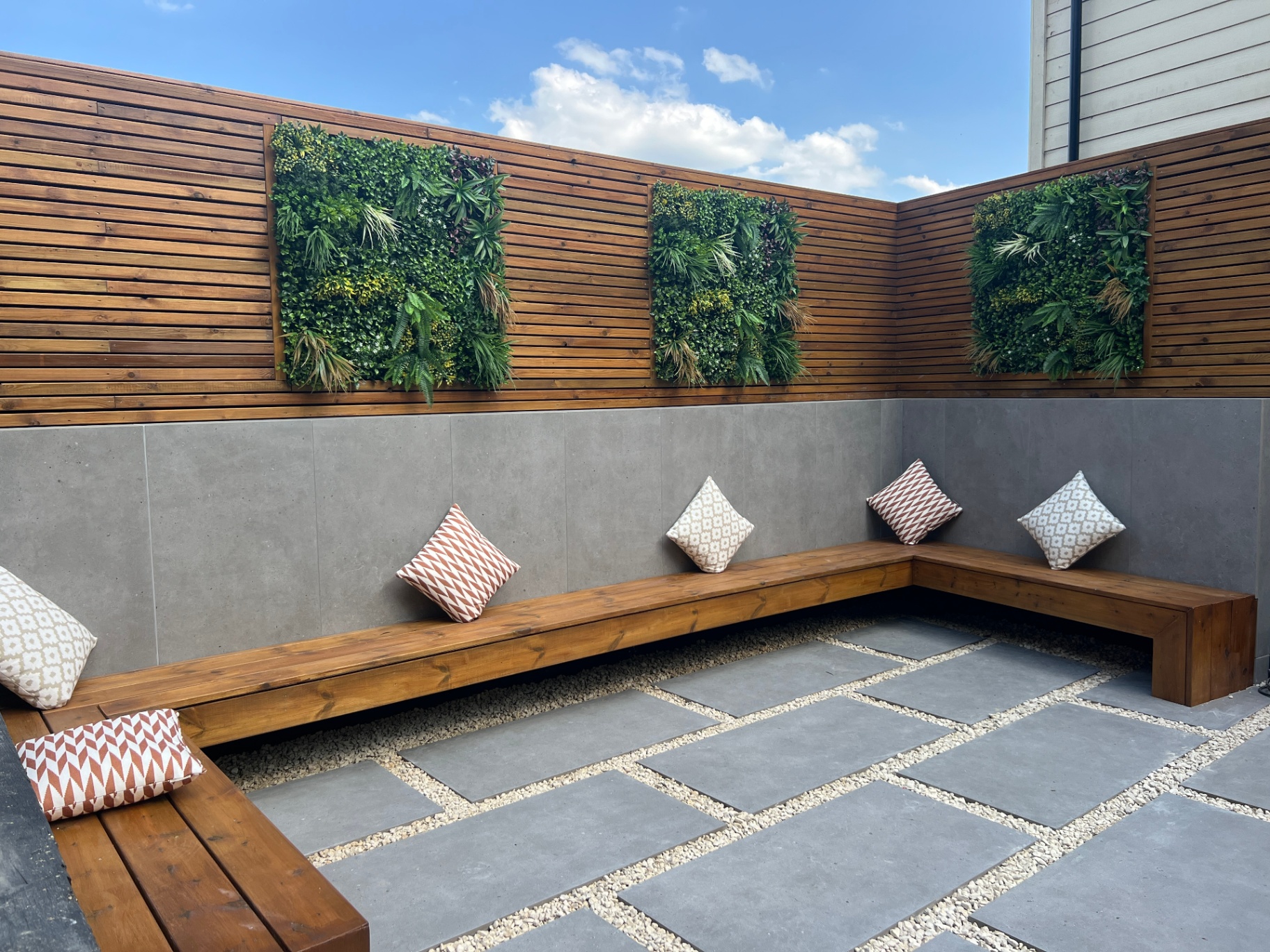 Wraparound timber bench seating beneath living green wall panels