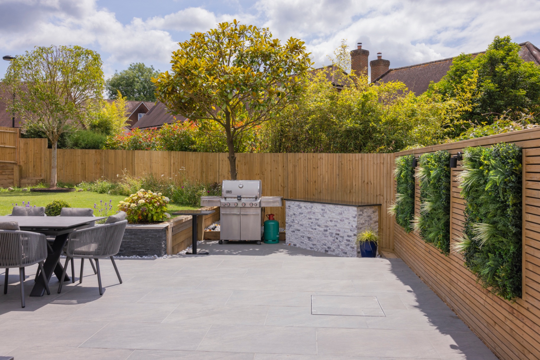 Porcelain terrace with dining set, BBQ station and living green wall panels